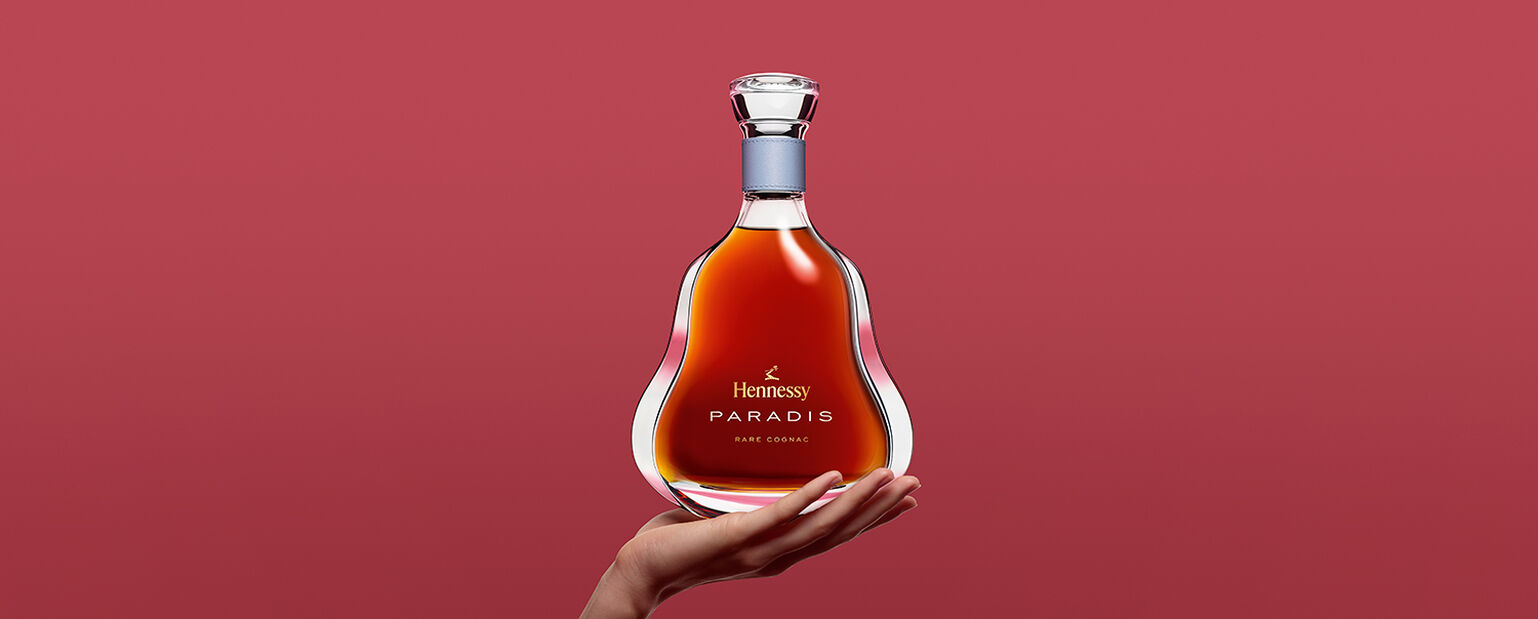 A hand holds a Hennessy Hands bottle.